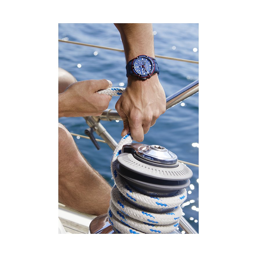 Jacques Lemans herrklocka i rostfritt stål på en mans arm, som håller ett rep på en båt med havet i bakgrunden.