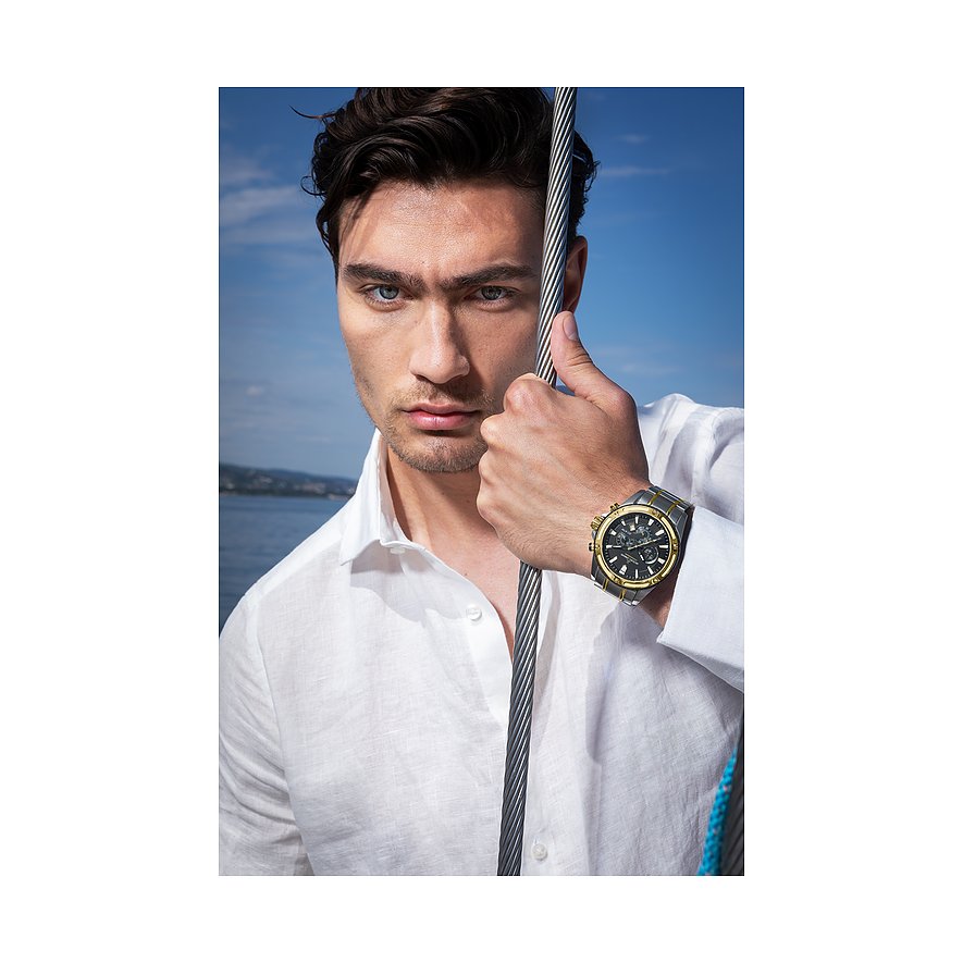 Ein Mannequin trägt einen Jacques Lemans Chronographen aus Edelstahl mit schwarzem und goldfarbenem Zifferblatt.