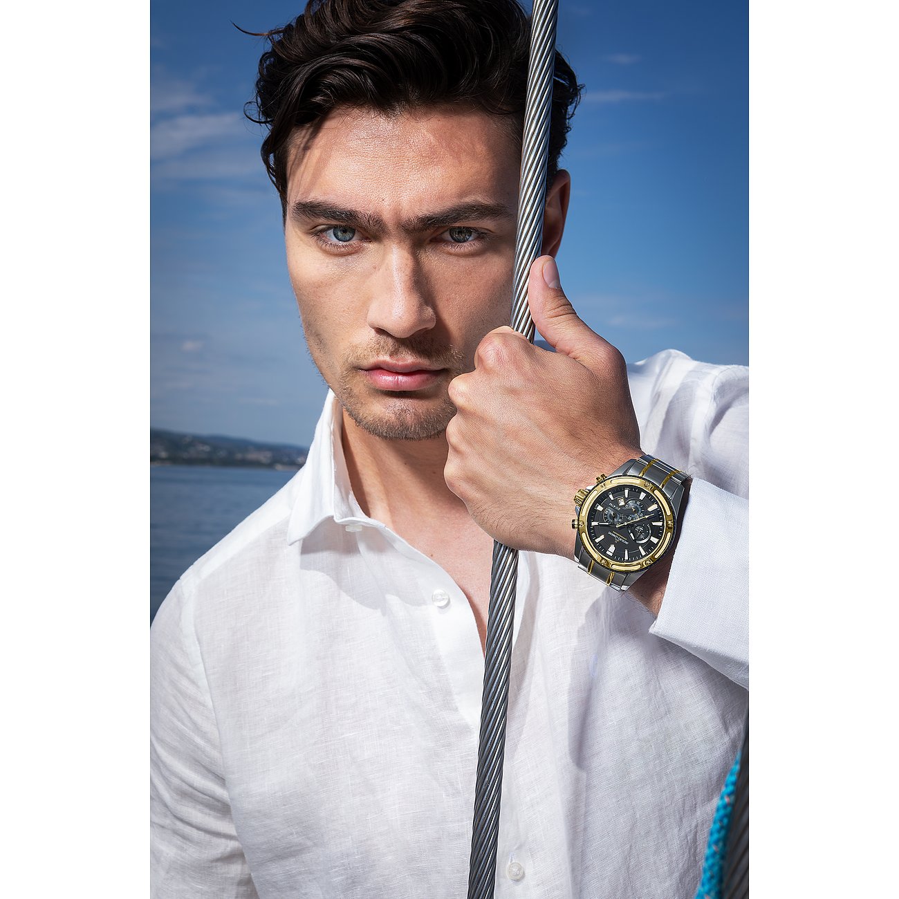 Ein Mannequin trägt einen Jacques Lemans Chronographen aus Edelstahl mit schwarzem und goldfarbenem Zifferblatt.