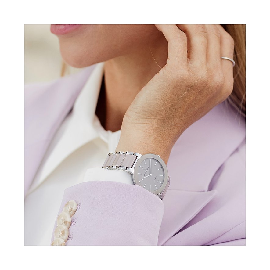 Nahaufnahme einer Jacques Lemans Damenuhr aus Edelstahl und Keramik am Handgelenk einer Frau.