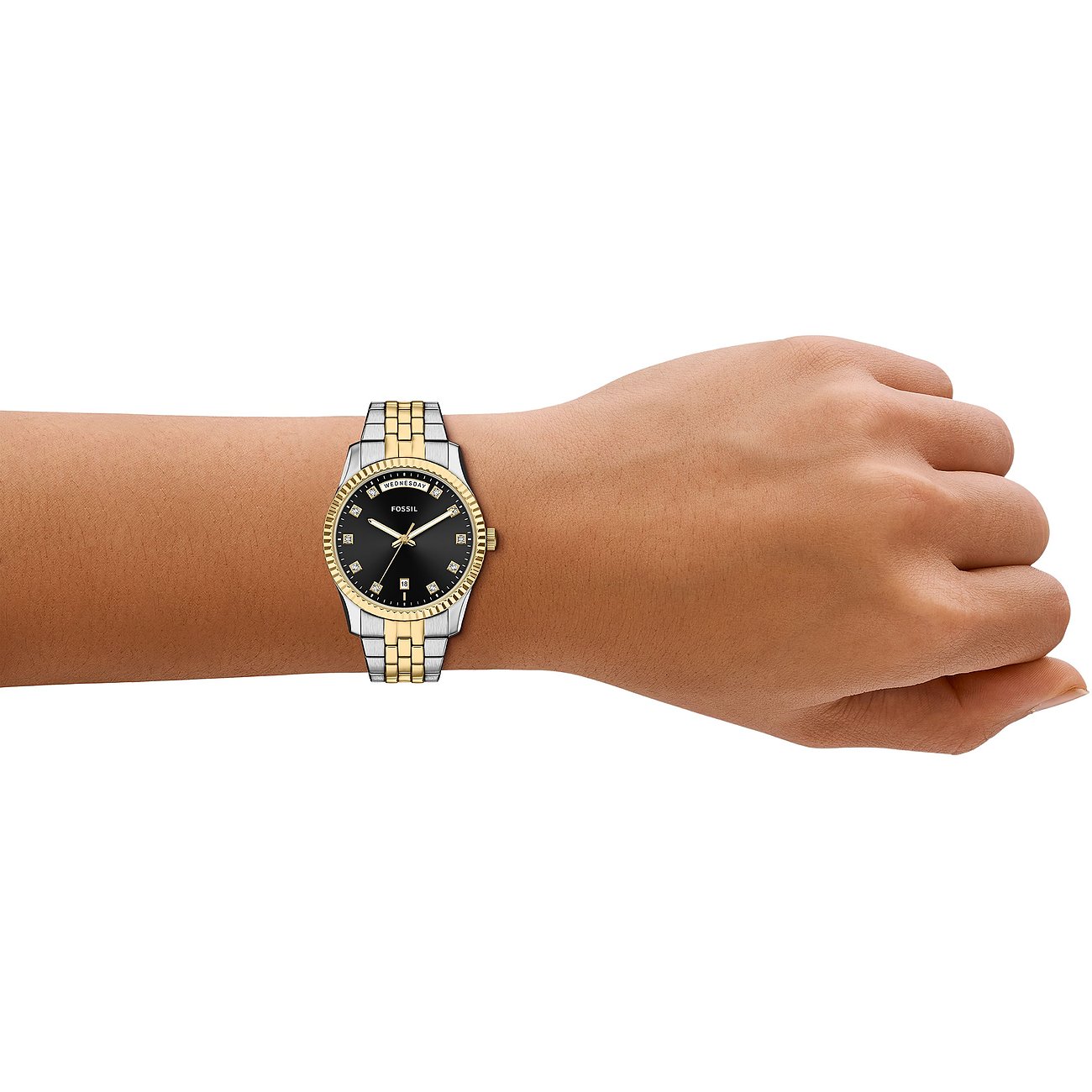 Die Fossil Damenuhr aus Edelstahl mit glänzenden Schmucksteinen und schwarzem Zifferblatt ist am Handgelenk zu sehen.