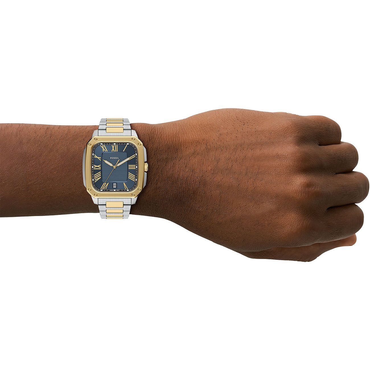 Die Fossil Herrenuhr aus blauem und goldfarbenem Edelstahl befindet sich am Handgelenk einer Person.