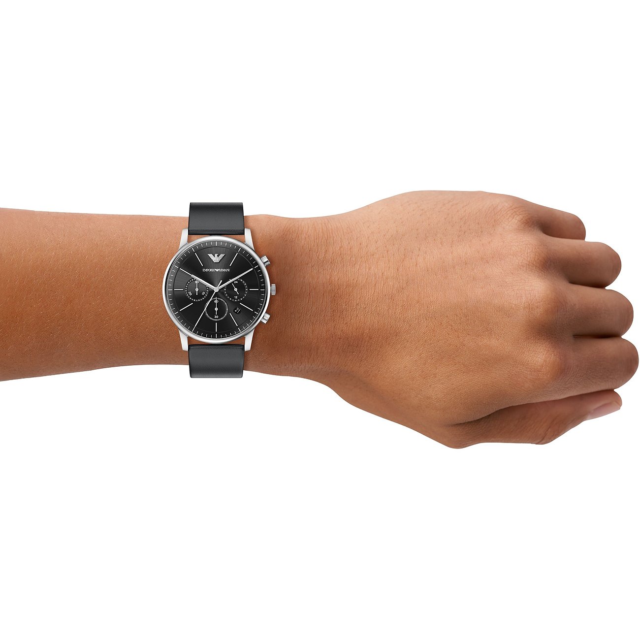 Eine Emporio Armani Herrenuhr aus Edelstahl mit schwarzem Zifferblatt und Lederarmband am Handgelenk getragen.