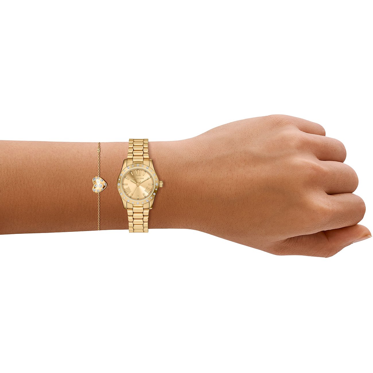 Set Michael Kors: orologio da polso in acciaio inox dorato e braccialetto abbinato con ciondolo a cuore, indossati.