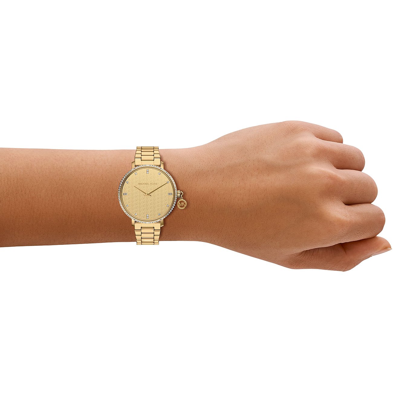 Guld Michael Kors dameur i rustfrit stål, båret på håndleddet, med glitrende urskive og logo-vedhæng.