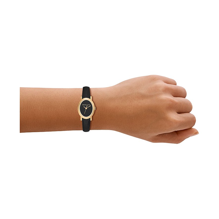 Montre femme Michael Kors dorée en acier inoxydable avec cadran et bracelet noirs au poignet d'une personne.