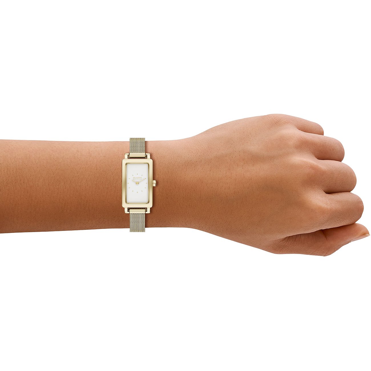 En Skagen damklocka i guldfärgat rostfritt stål sitter på en persons handled.
