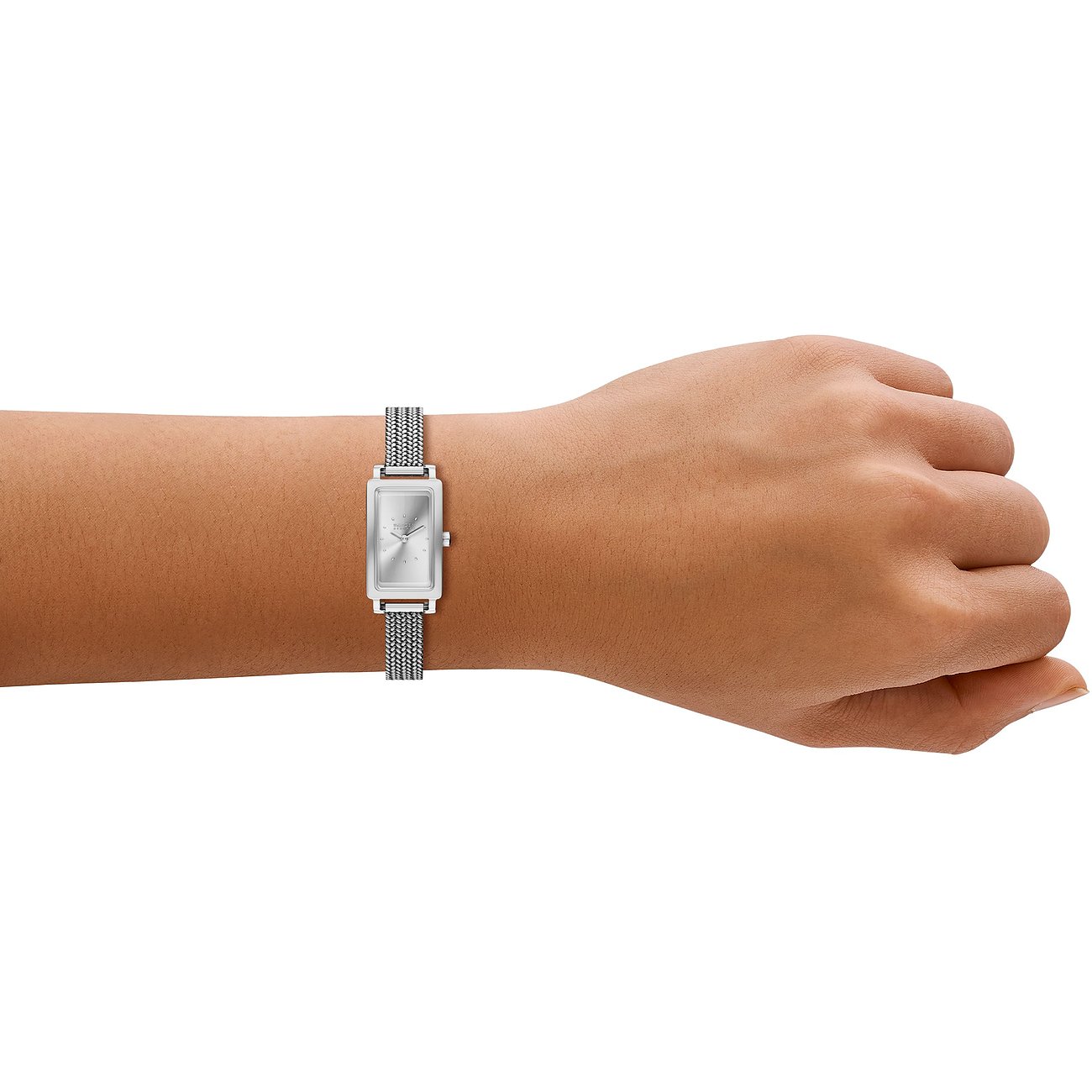 En Skagen damklocka i rostfritt stål med rektangulär urtavla och silverfärgad milaneselänk, buren på handleden.