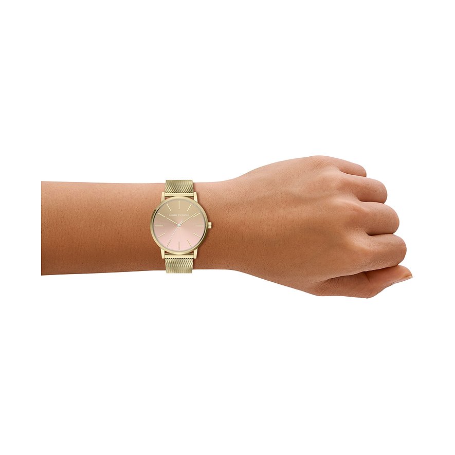 Une montre femme Armani Exchange en acier inoxydable doré avec cadran rose, portée au poignet.