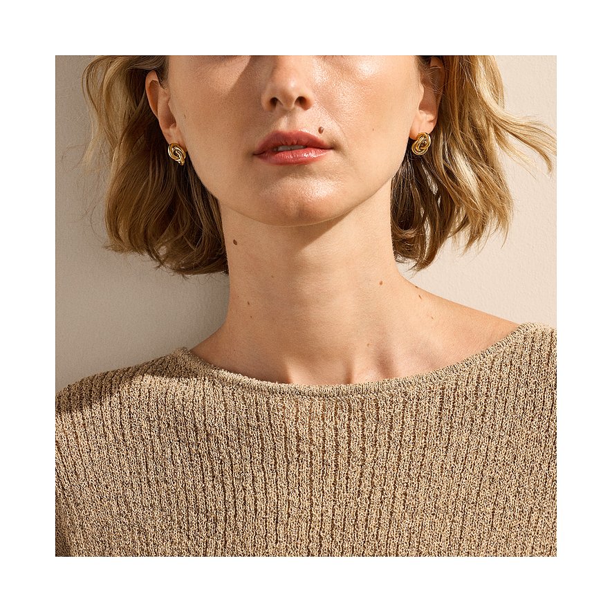 Modellen bär Skagen örhängen i rostfritt stål med intrikat form.