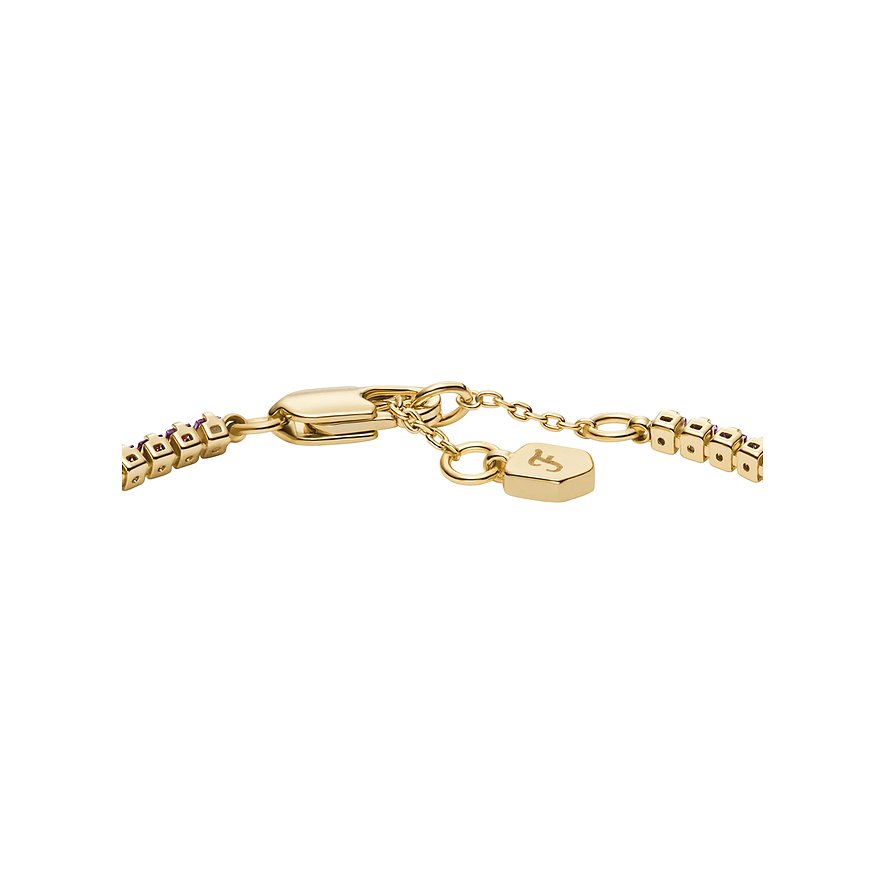 Gros plan du fermoir d'un bracelet Fossil en métal doré avec pierres colorées et petit pendentif logo Fossil.