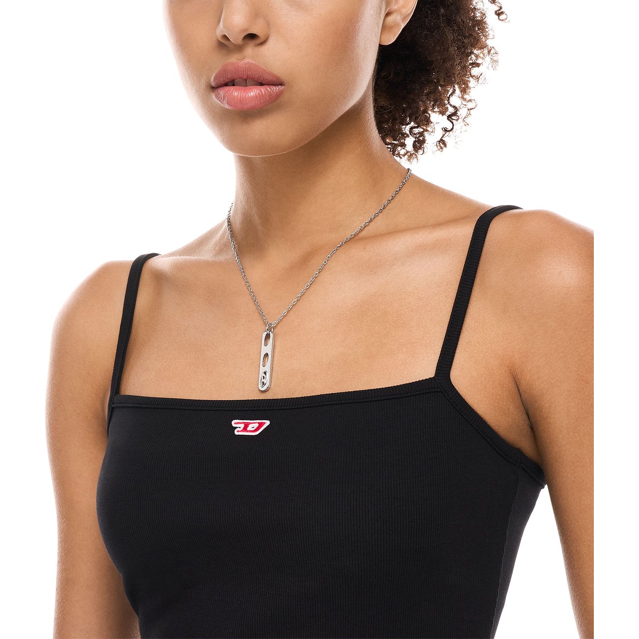 Närbild på kvinna med Diesel-halsband i rostfritt stål, med vertikalt hänge och präglat logotyp.