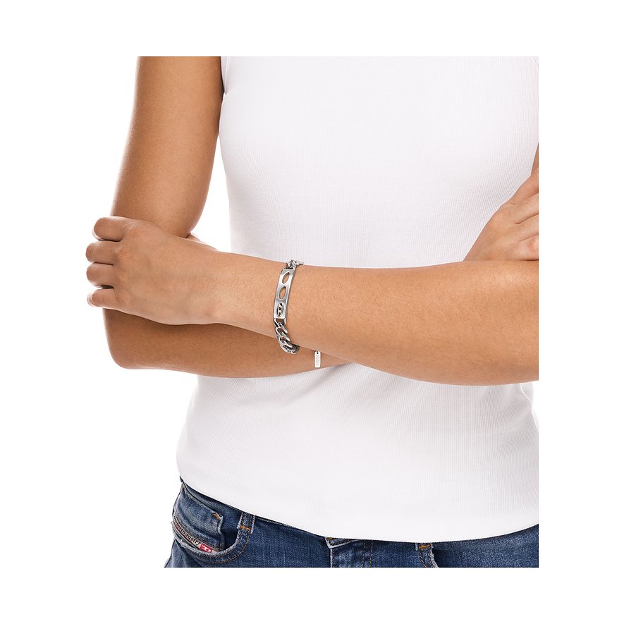 Am Handgelenk einer Person sichtbares Diesel-Kettenarmband aus Edelstahl mit einem gravierten Mittelstück.