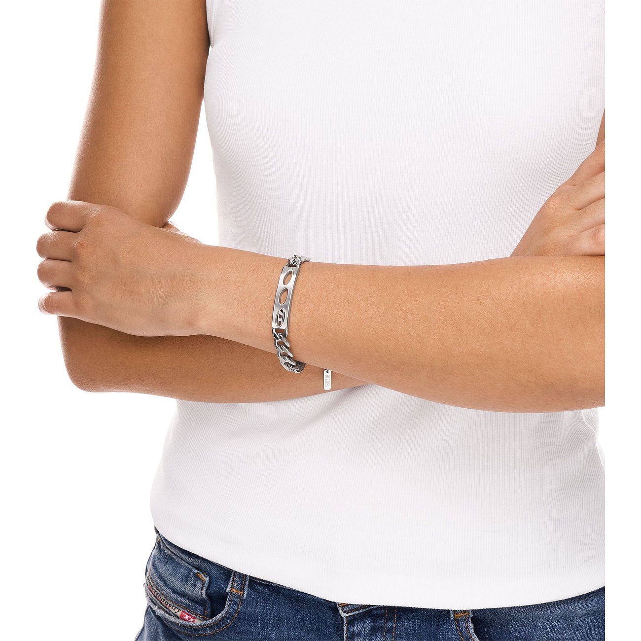 Am Handgelenk einer Person sichtbares Diesel-Kettenarmband aus Edelstahl mit einem gravierten Mittelstück.