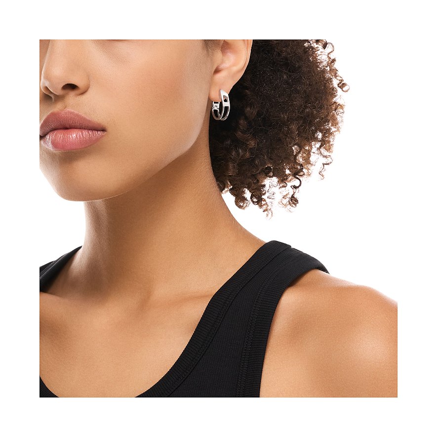 Närbild av en person med ett guldfärgat Diesel örhänge i rostfritt stål på höger öra, med modern utskuren design.