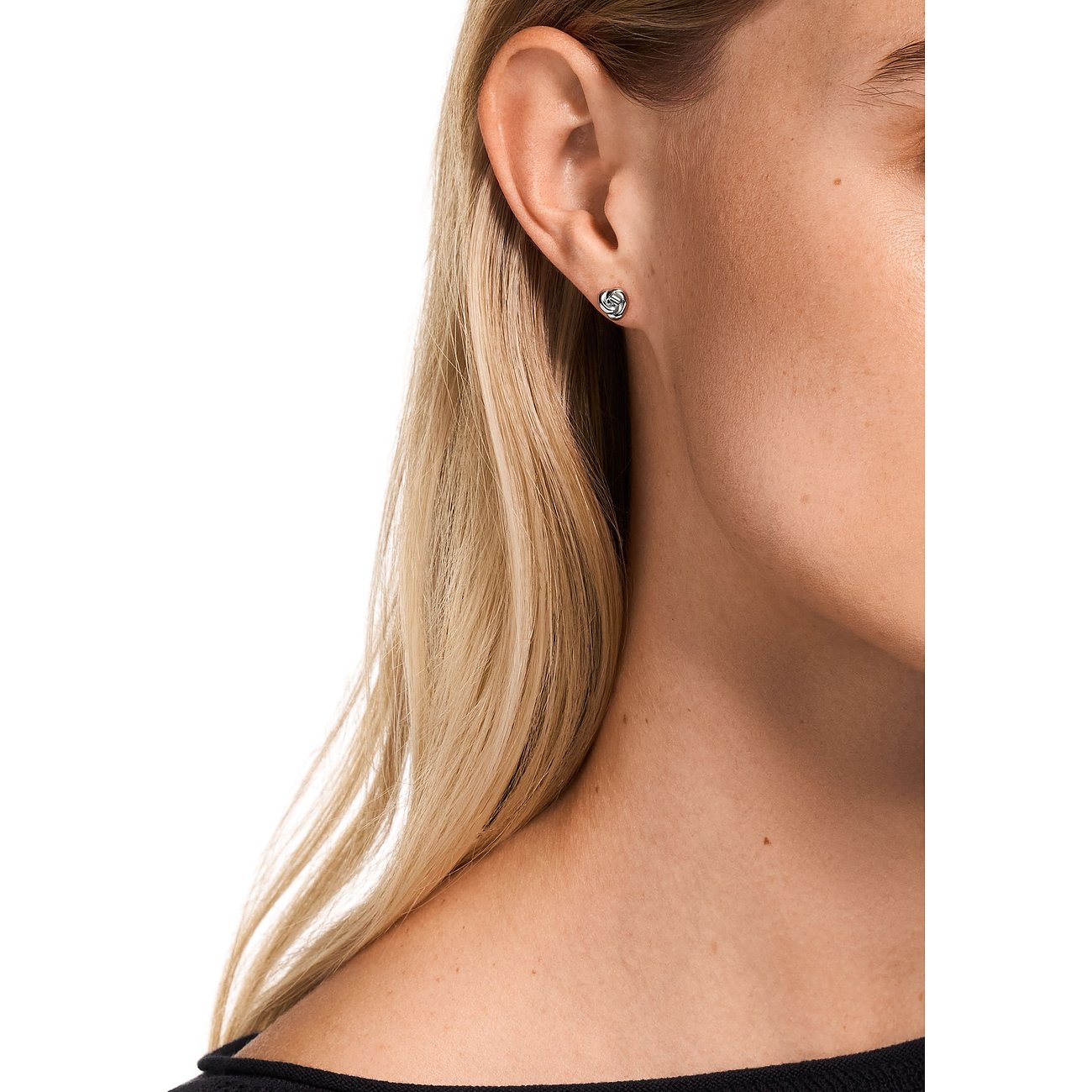 Primo piano di donna bionda con singolo orecchino tondo Emporio Armani in argento 925.