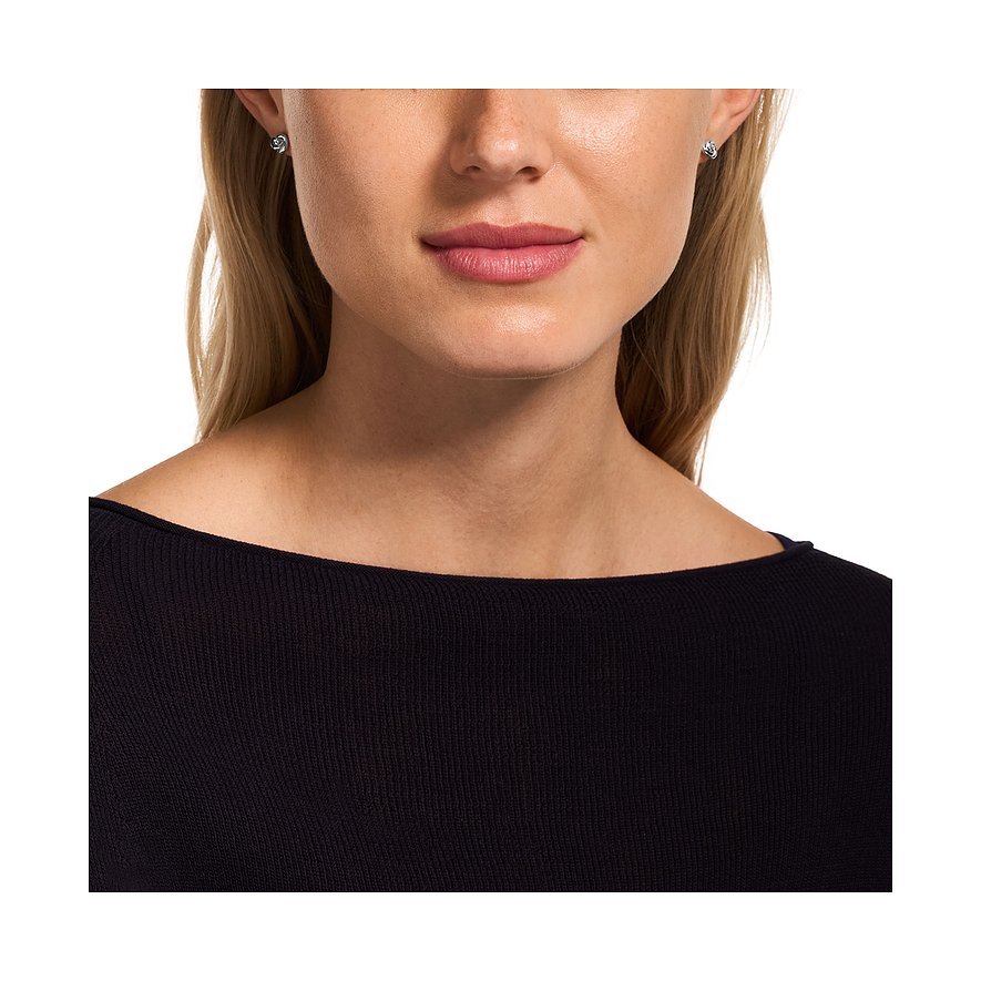 Primo piano di donna che indossa piccoli orecchini circolari Emporio Armani in argento 925.