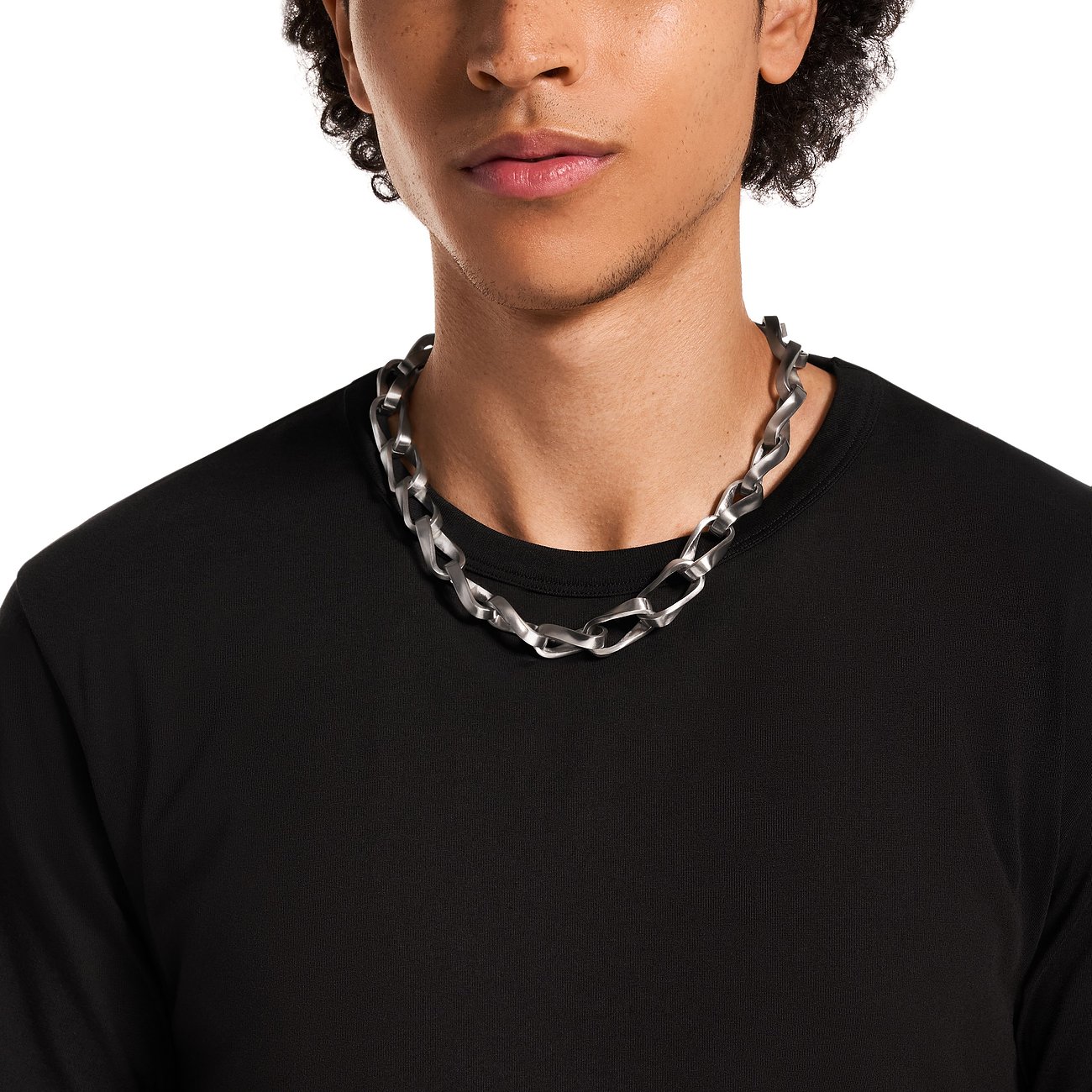 Un uomo indossa una collana Emporio Armani in acciaio inossidabile con grandi maglie intrecciate.