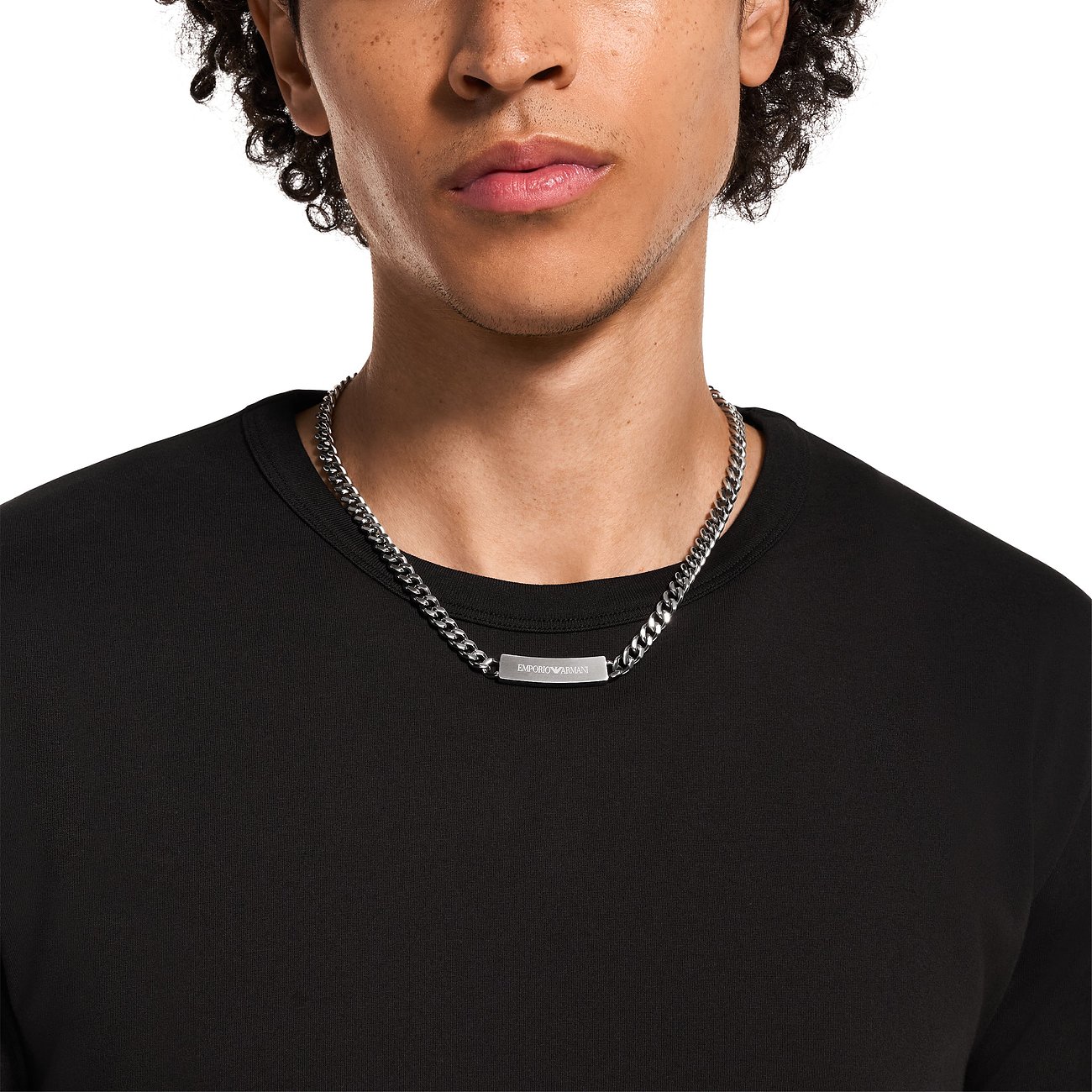 Model trägt silberfarbene Emporio Armani Halskette aus Edelstahl mit breiter Gliederung und kleinem Namensschild.