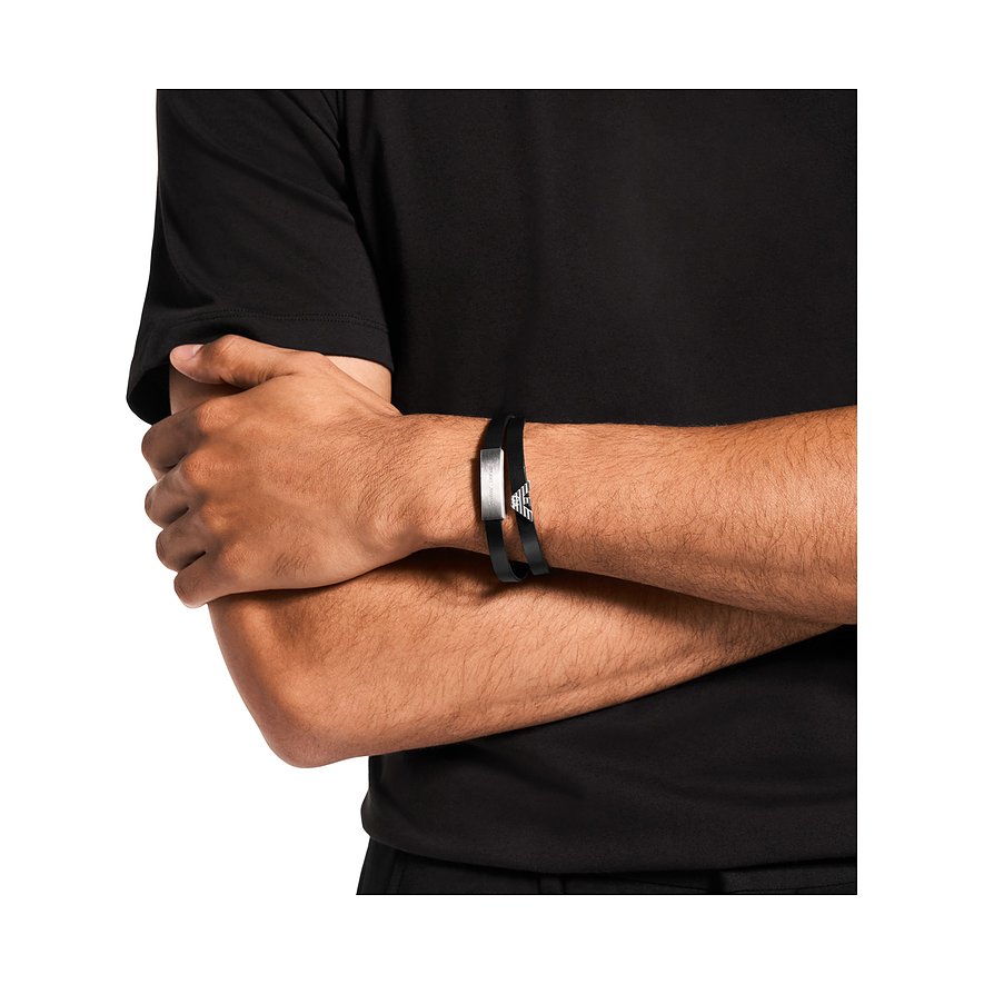 En man bär ett Emporio Armani-armband i svart läder och rostfritt stål, med varumärkets ikoniska örnlogo.