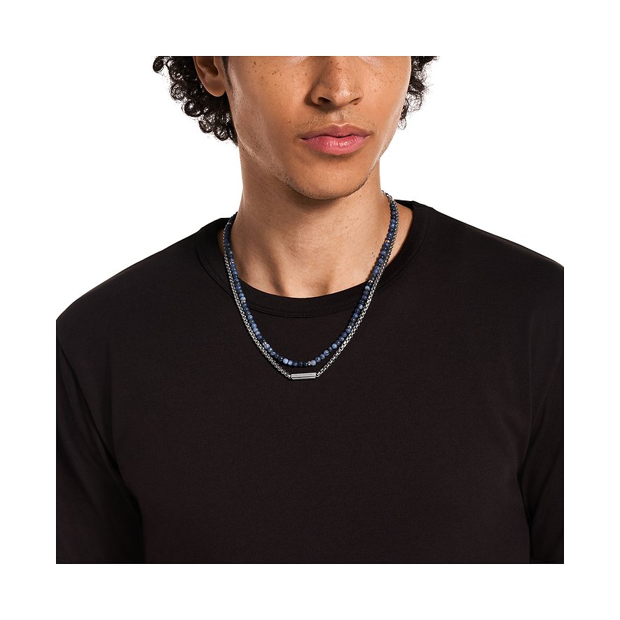 Der Emporio Armani Halsschmuck aus Edelstahl mit Sodalith Farbsteinen ist als Doppelkette an einem Mann zu sehen.