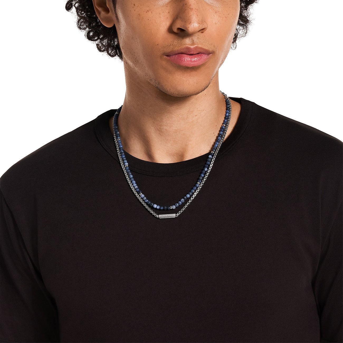 Der Emporio Armani Halsschmuck aus Edelstahl mit Sodalith Farbsteinen ist als Doppelkette an einem Mann zu sehen.