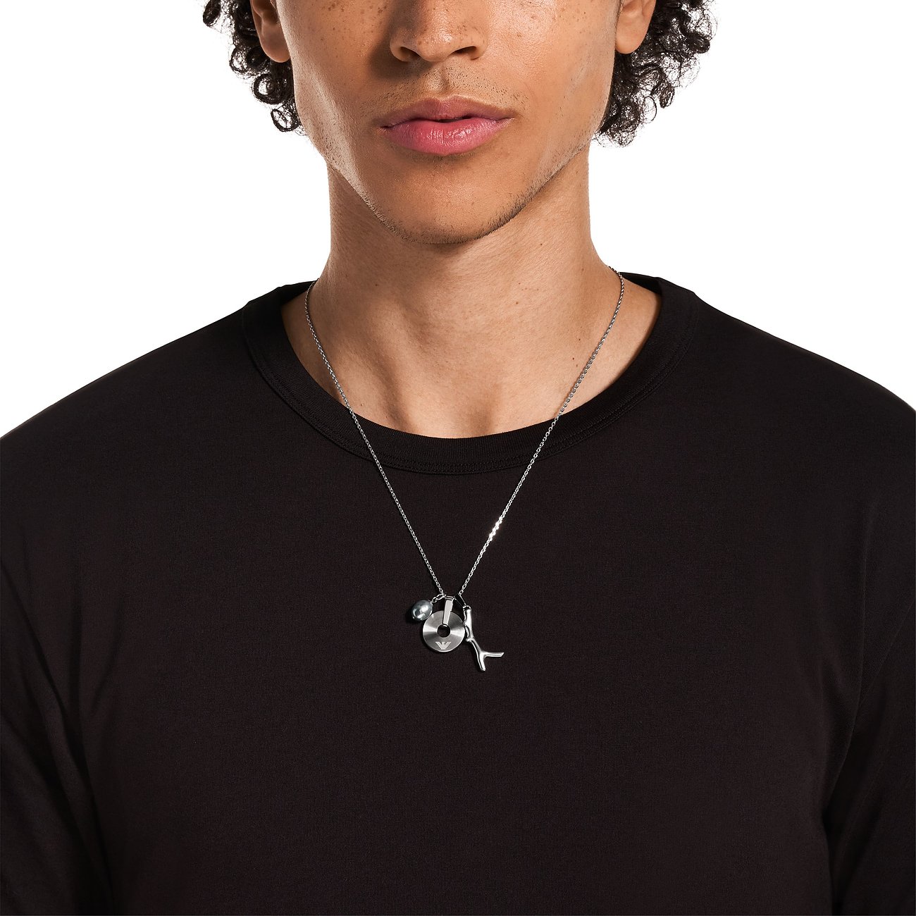 Emporio Armani Edelstahlkette mit runden und geformten Anhängern, einer davon mit Perle, getragen von einem Model.
