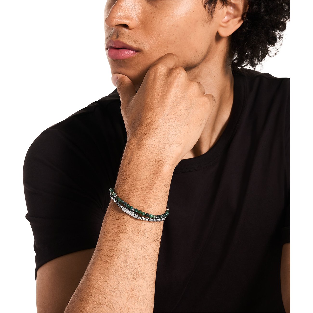 En man bär ett Emporio Armani-armband i rostfritt stål och grön agatsten på höger handled.