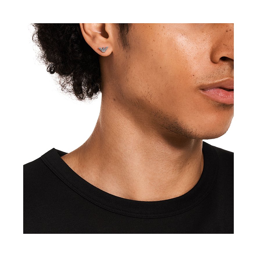 Nahaufnahme eines Ohres, das einen Emporio Armani Ohrstecker aus Edelstahl mit dem Markenlogo tr&aumlgt.
