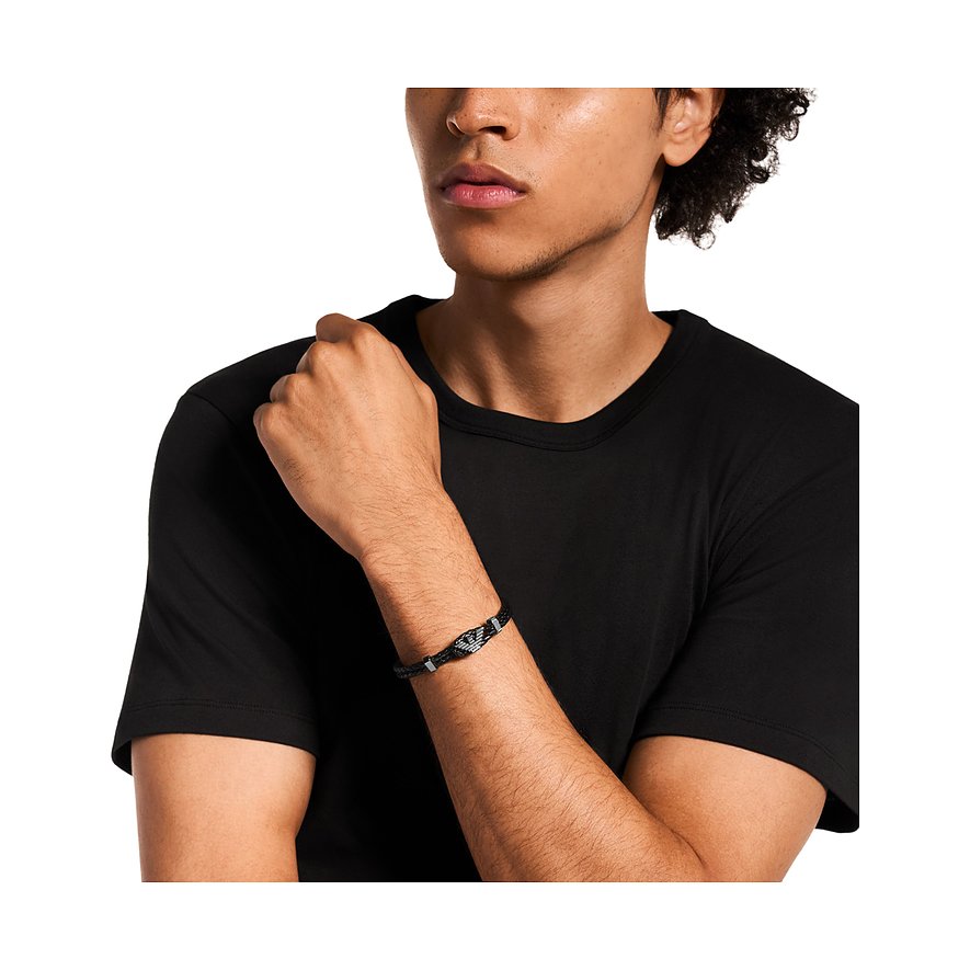 Een stijlvolle Emporio Armani leren en roestvrijstalen armband om de pols van een man met een zwart T-shirt.