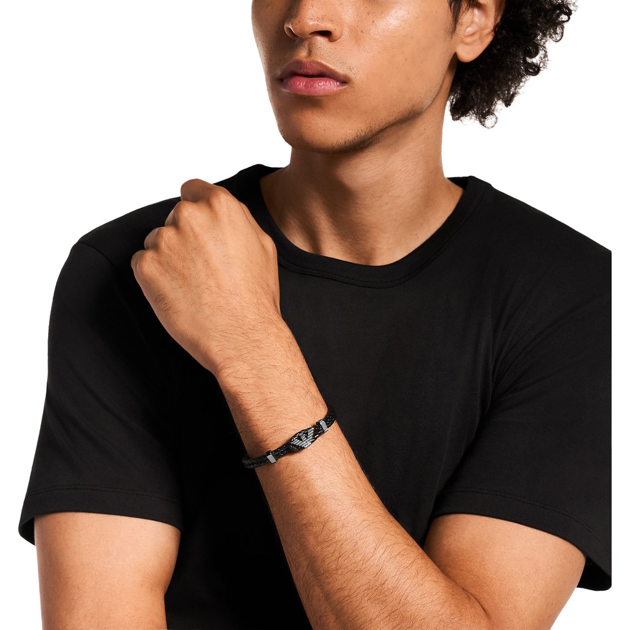 Een stijlvolle Emporio Armani leren en roestvrijstalen armband om de pols van een man met een zwart T-shirt.
