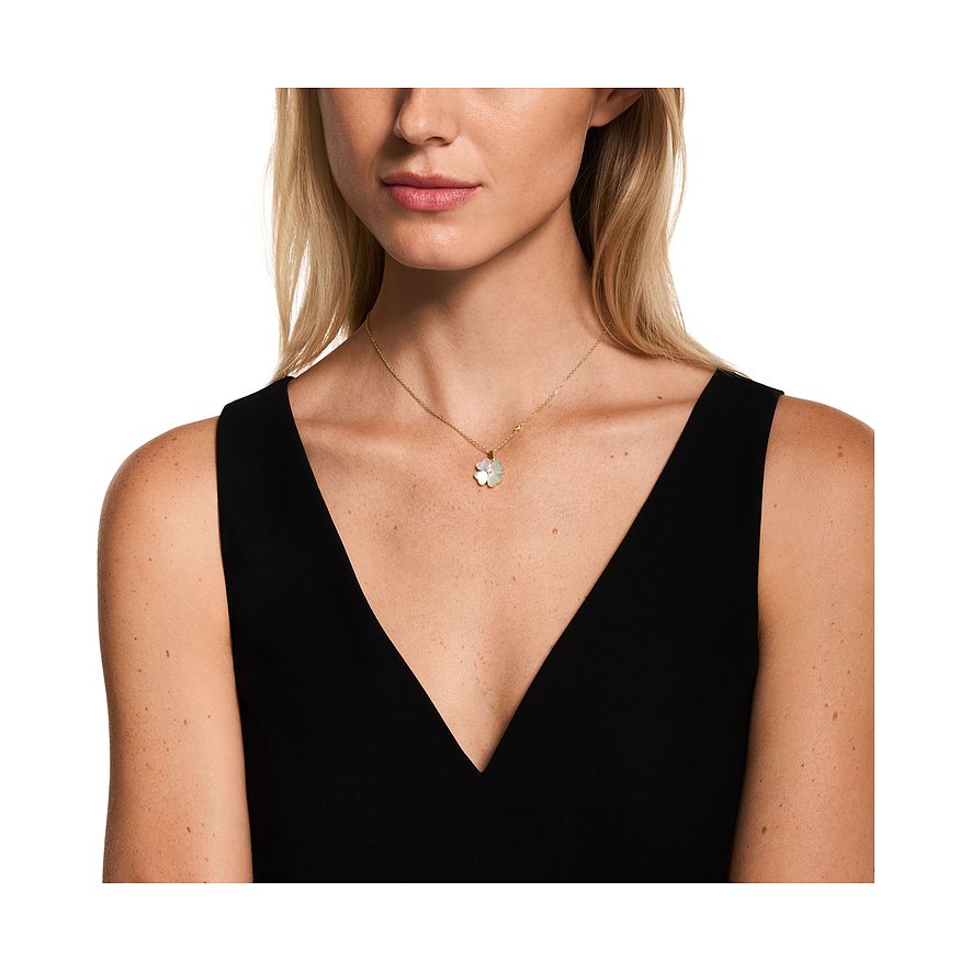 Nahaufnahme einer Frau mit hellblondem Haar, die eine goldene Emporio Armani Halskette mit Perlmutt-Kleeblatt trägt.