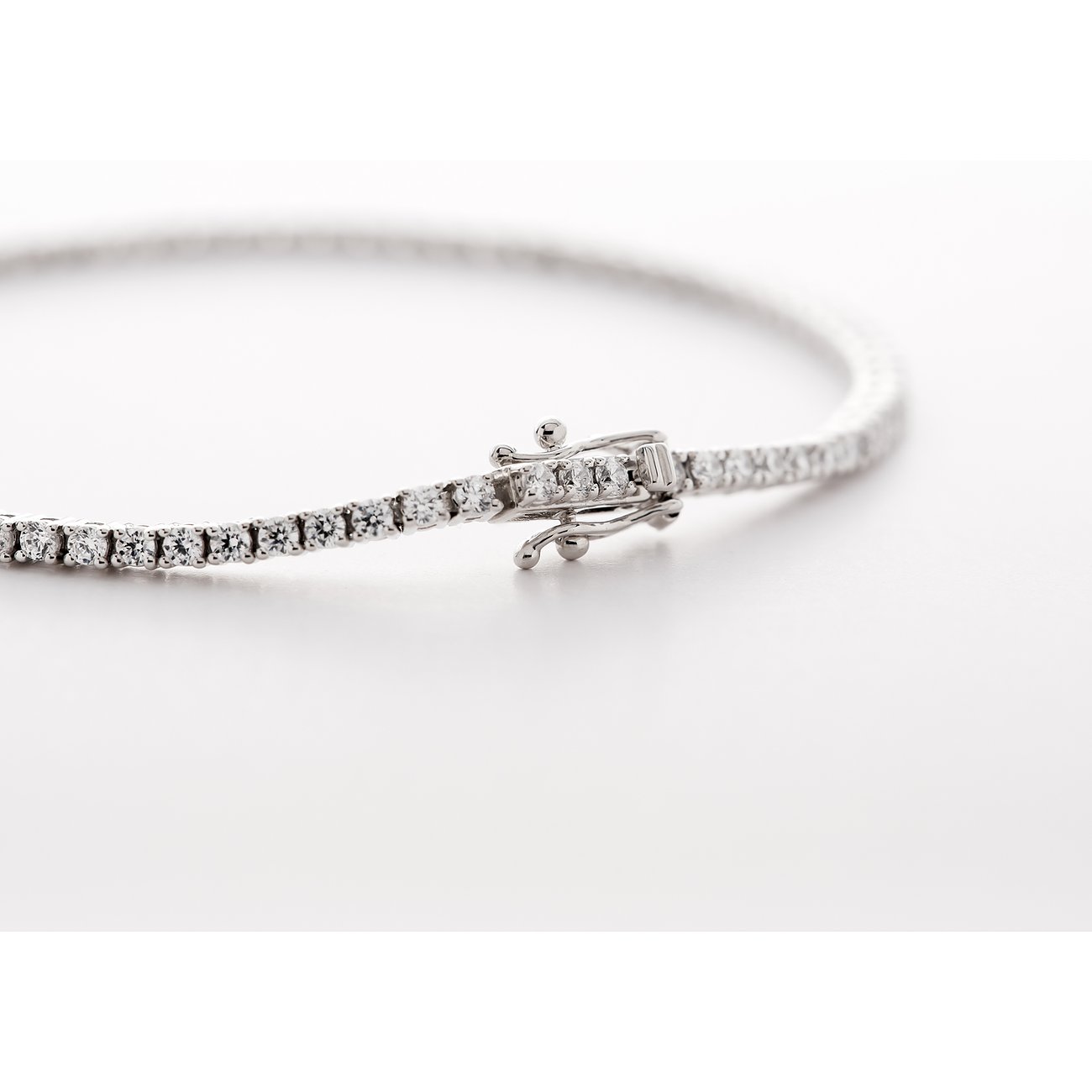 Nahaufnahme eines CHRIST Tennisarmband aus 585er Weißgold, besetzt mit funkelnden Diamanten, der Verschluss ist mittig.