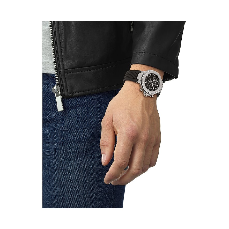 Nahaufnahme einer Tissot Herrenuhr aus Edelstahl am Handgelenk eines Mannes, der eine schwarze Lederjacke trägt.
