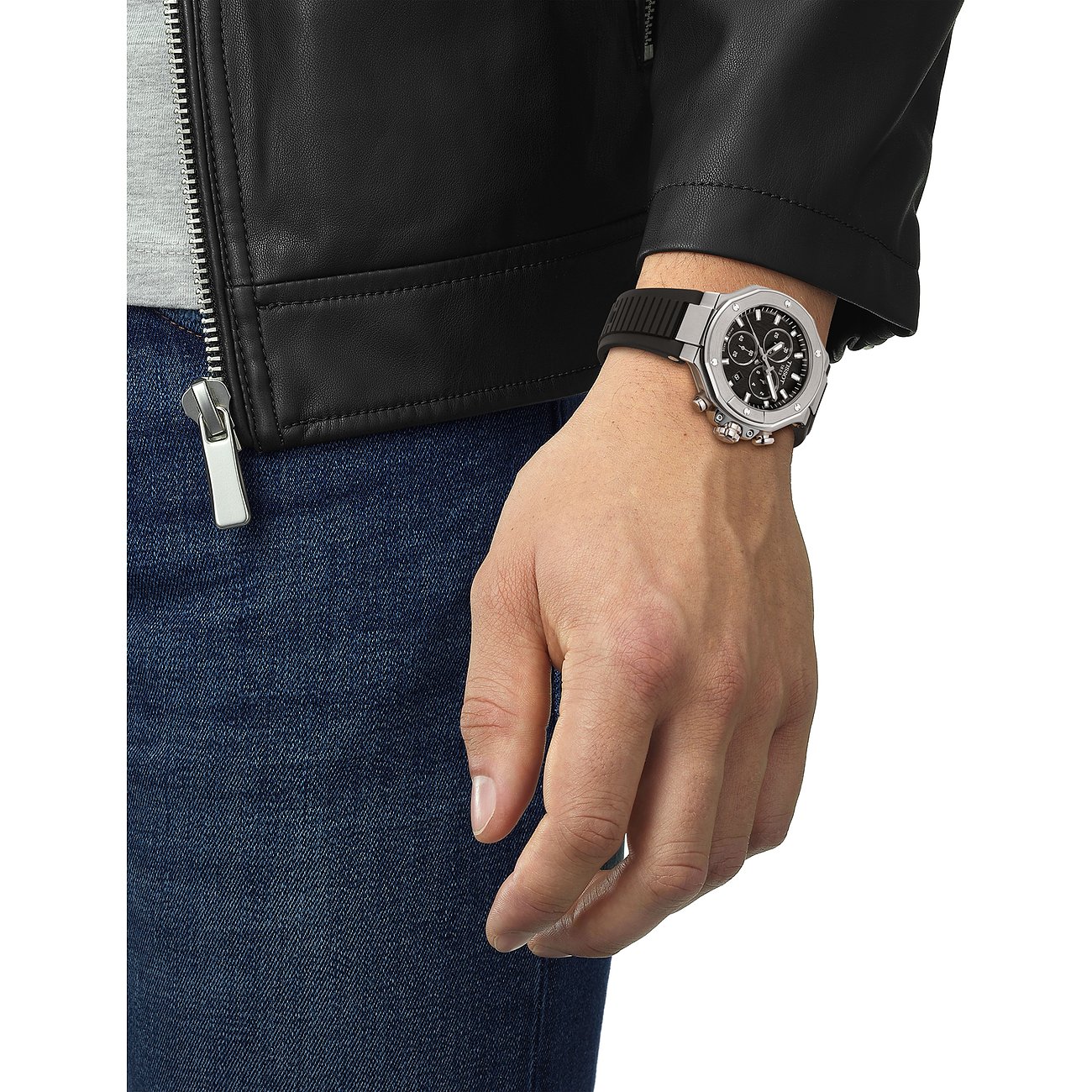 Nahaufnahme einer Tissot Herrenuhr aus Edelstahl am Handgelenk eines Mannes, der eine schwarze Lederjacke trägt.