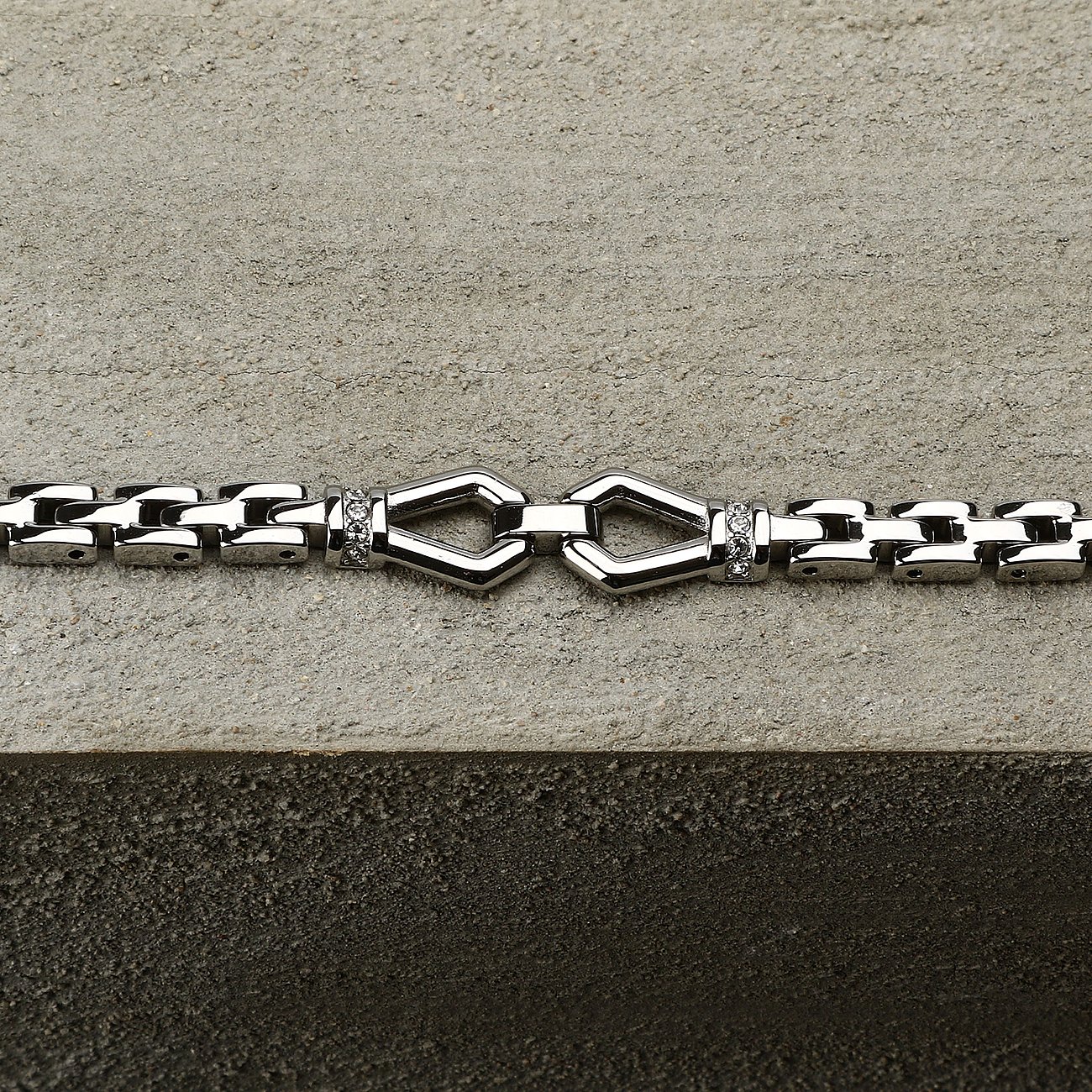 Morellato Edelstahl-Armband mit funkelnden Kristall-Farbsteinen und dekorativer Kette auf grauer Steinplatte.