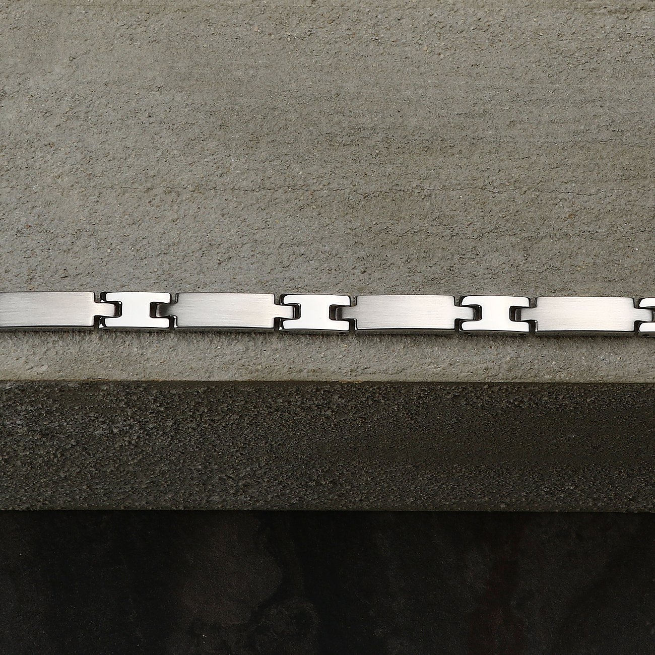 Morellato armbånd i rustfrit stål: slanke, børstede rektankulære led, skinnende H-formede forbindelsesstykker.