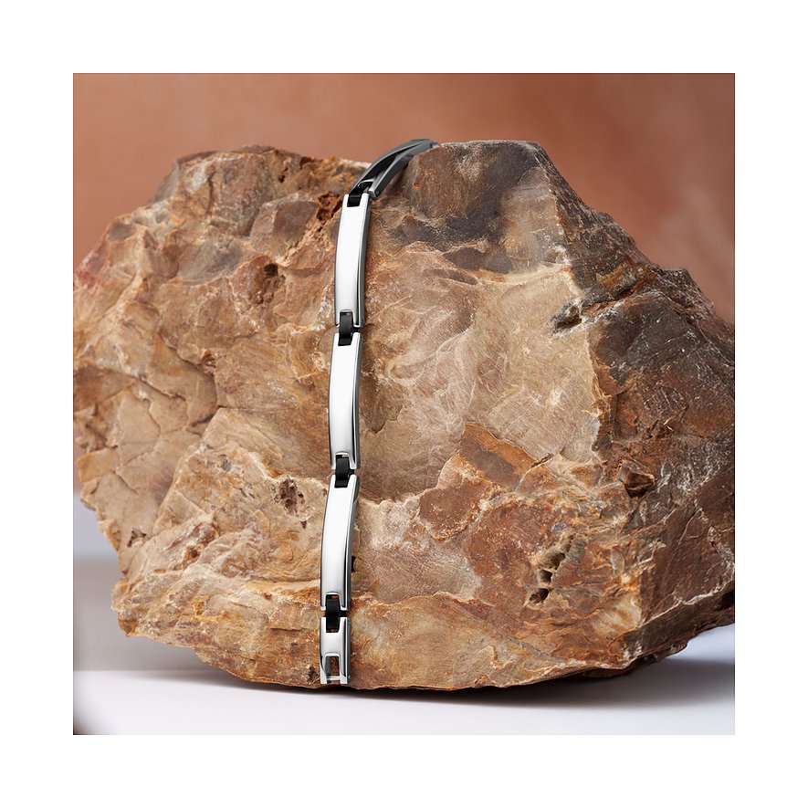 Das Morellato Armband aus glänzendem Edelstahl zeigt abwechselnd silberne und schwarze Glieder auf einem Felsen.