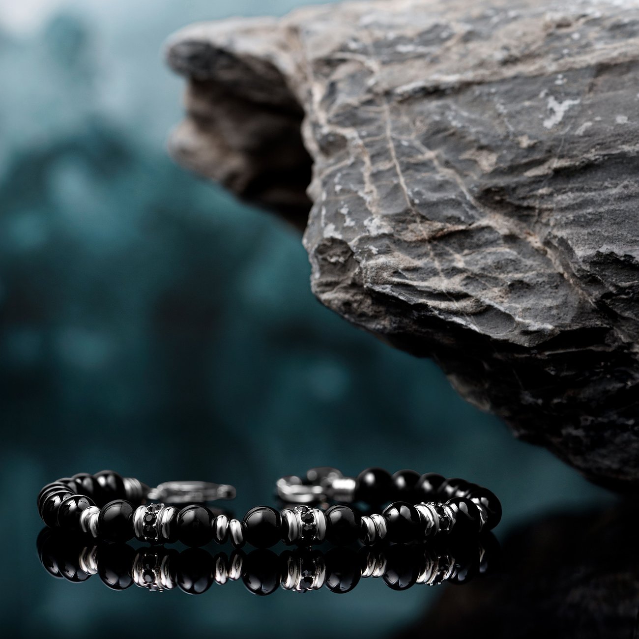 Morellato armband i rostfritt stål och svart onyx, med en frostad klippa i bakgrunden.