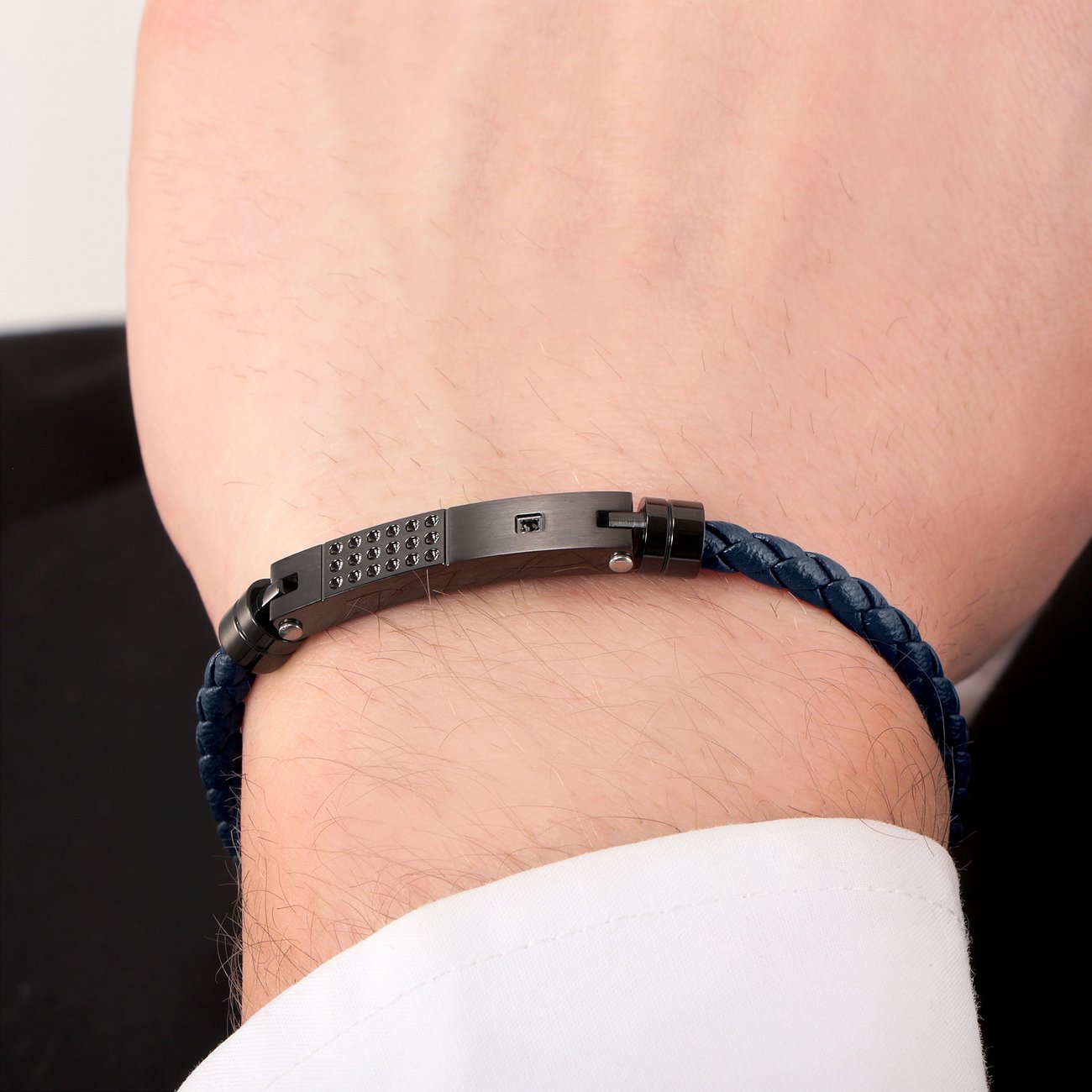 Morellato Armband am Handgelenk eines Mannes: geflochtenes blaues Leder, Edelstahlverschluss mit schwarzen Kristallen.