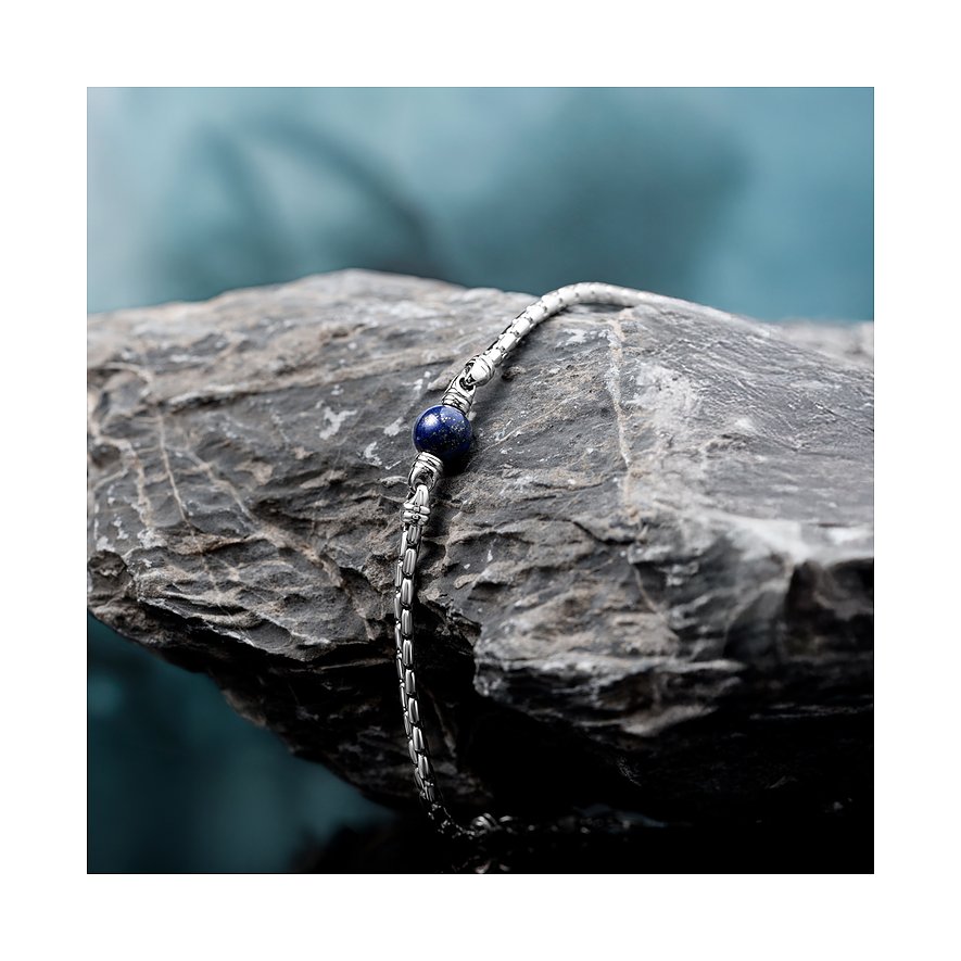 Morellato Armschmuck aus Edelstahl mit einem dunkelblauen Lapislazuli-Farbstein in der Mitte, auf einem Felsen.