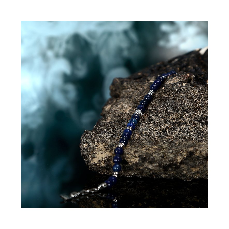 Morellato-armbandet i rostfritt stål med mörkblå lapis lazuli-färgstenar ligger på en mörk klippa.