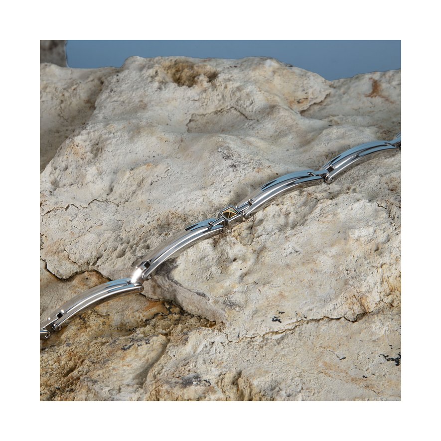 Morellato Armschmuck aus Edelstahl und Gelbgold, liegend auf einem hellbeigen Felsen.