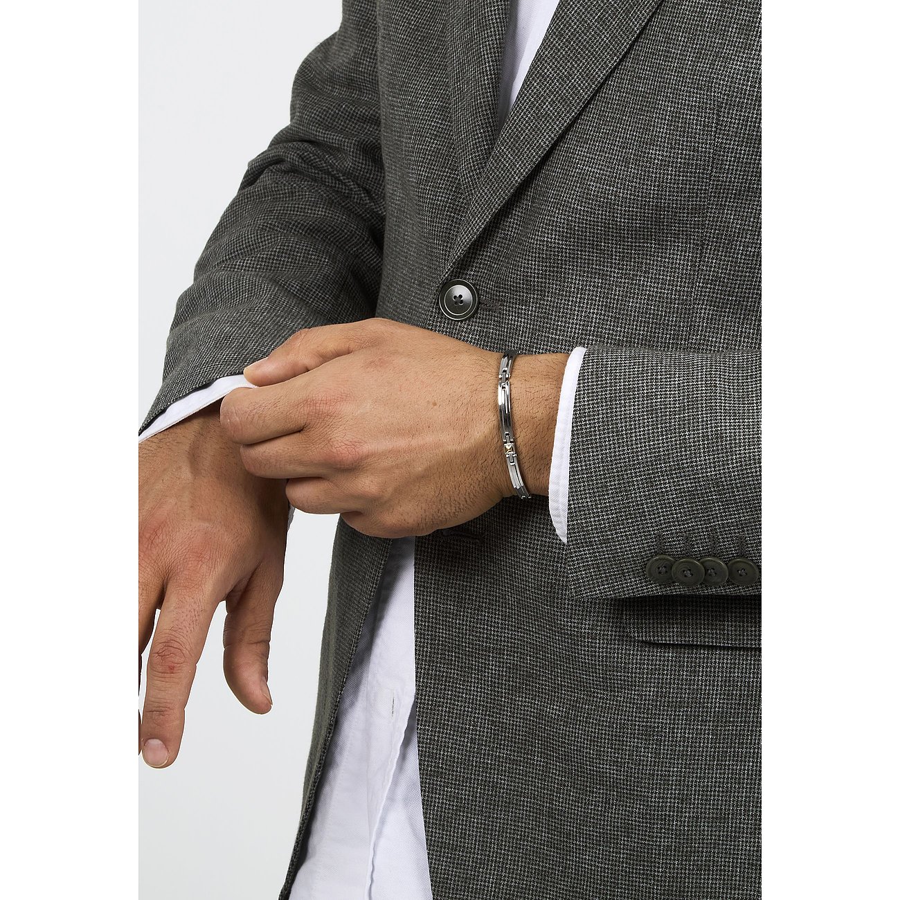 Nahaufnahme eines Mannes im grauen Anzug und weißem Hemd, der ein Morellato Armband aus Edelstahl an seinem Handgelenk trägt.