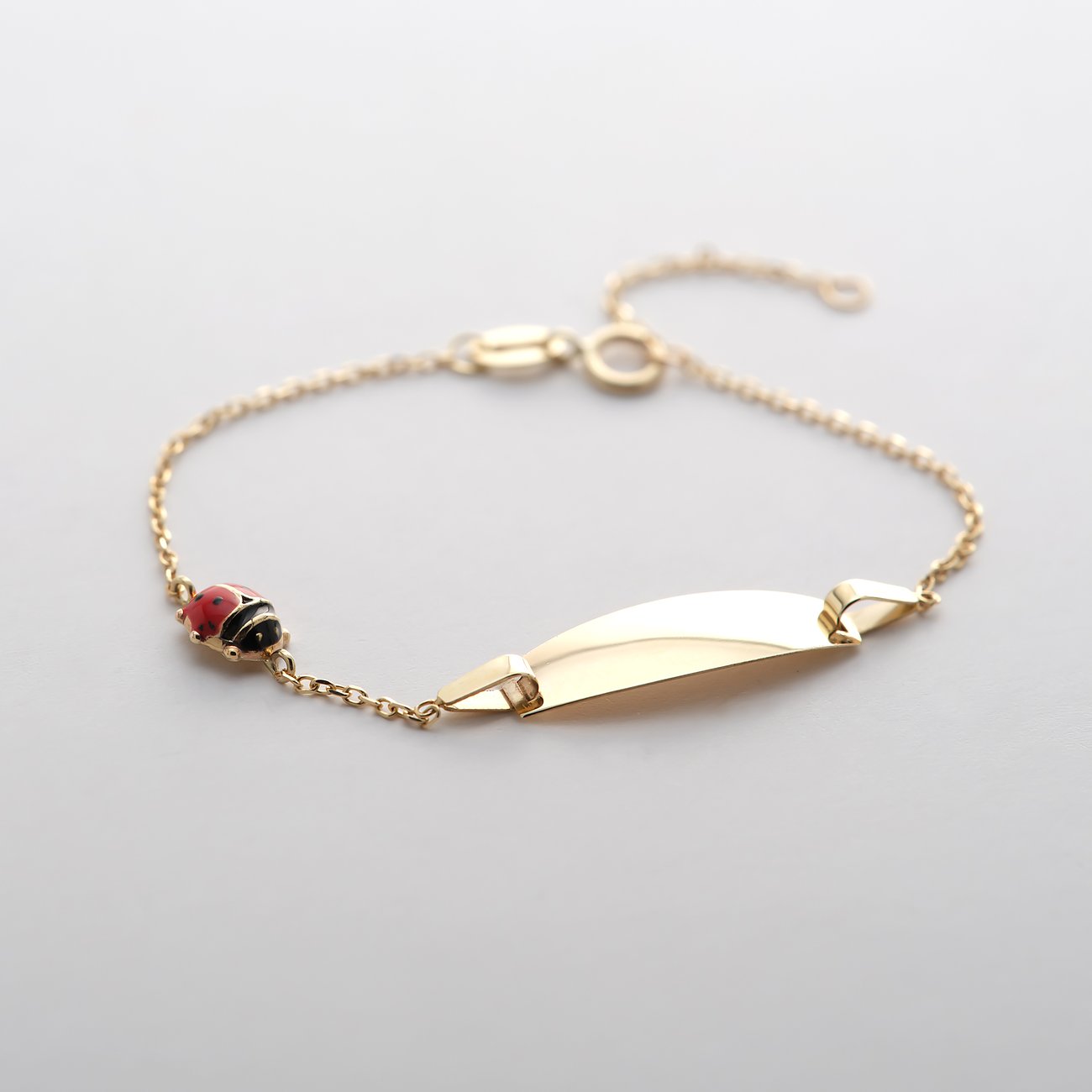 FAVS Little Friends Identitätsarmband aus 375er Gelbgold mit Marienkäfer-Motiv und glänzender Plakette.
