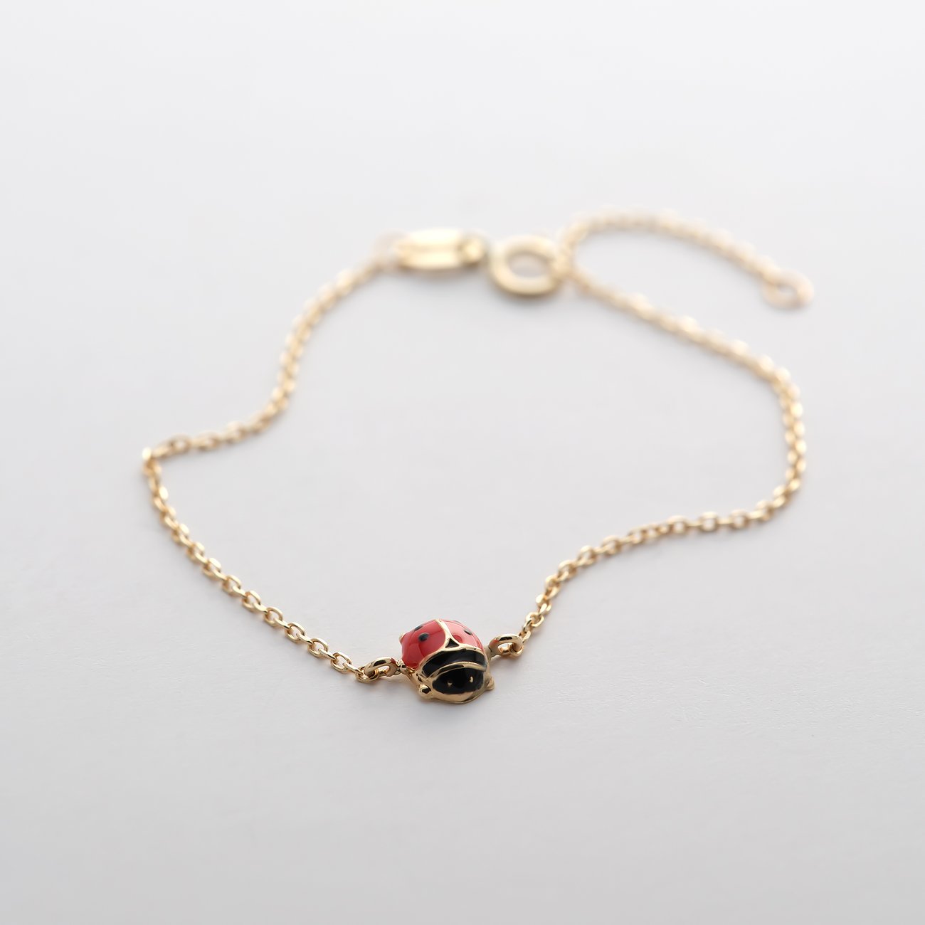 FAVS Little Friends Armschmuck aus 375er Gelbgold mit einem kleinen Marienkäfer-Anhänger.