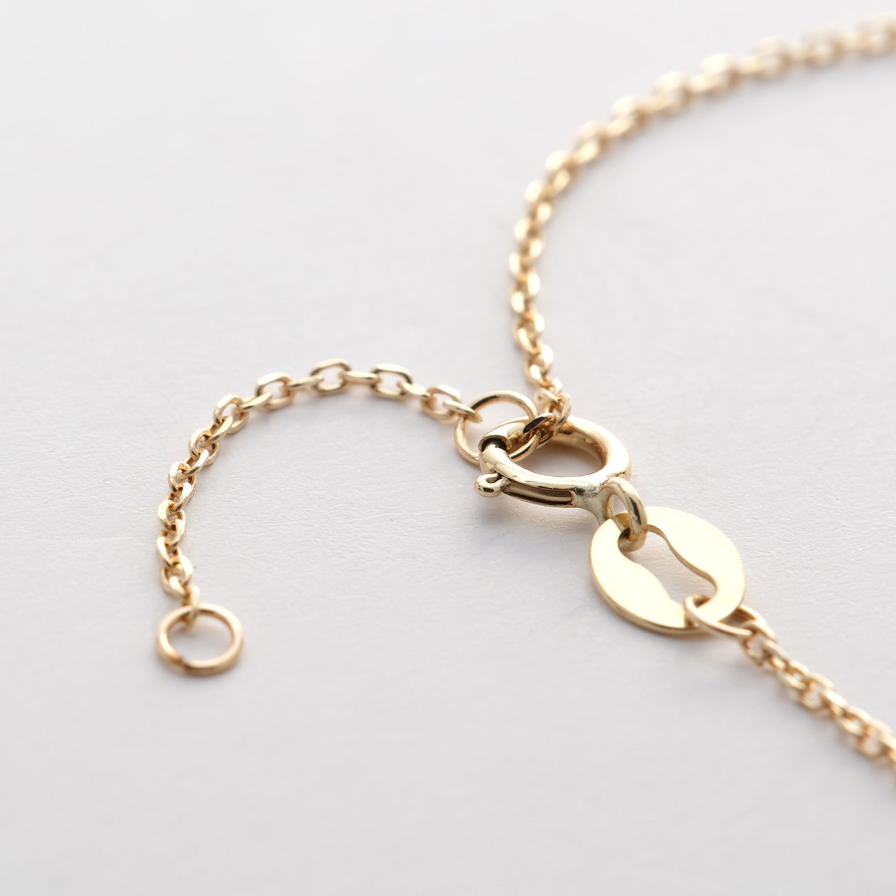 Nahaufnahme des Verschlusses eines FAVS Little Friends Armschmucks aus 375er Gelbgold mit einer Verlängerungskette.