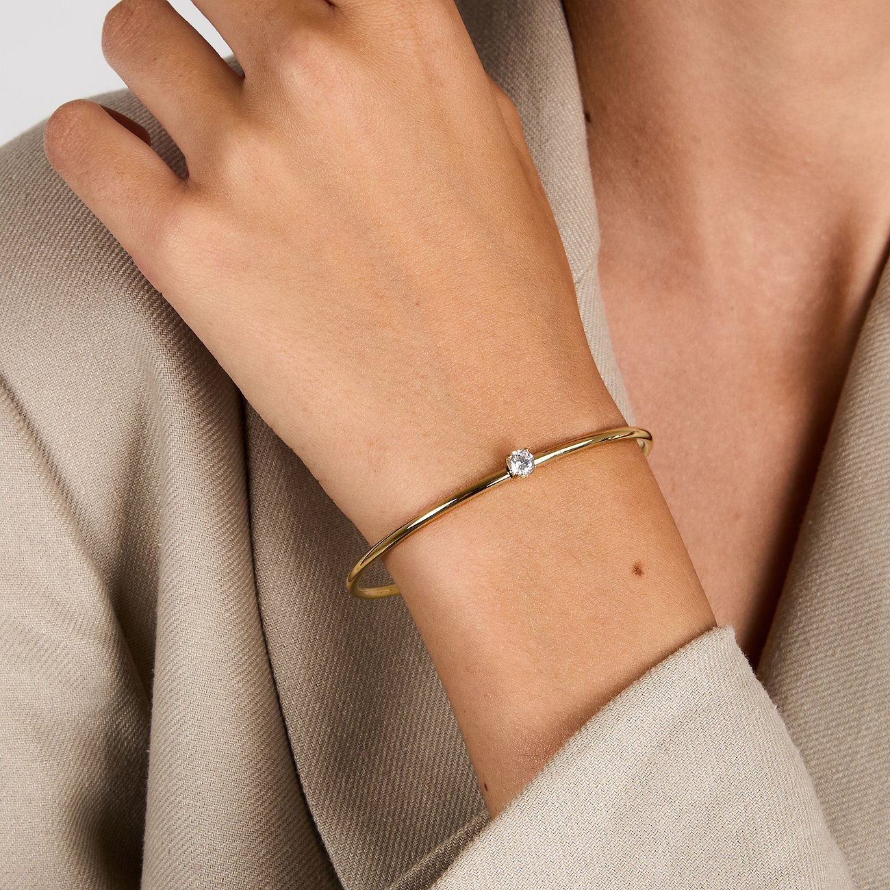 Bracciale Morellato in acciaio inossidabile color oro con zircone al polso di una modella.
