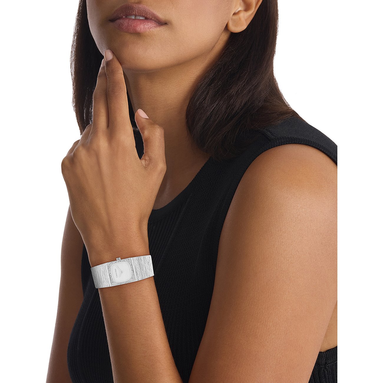 Nahaufnahme einer Calvin Klein Damenuhr aus Edelstahl am Handgelenk eines Models. Rechteckiges Zifferblatt mit runder Umrandung.