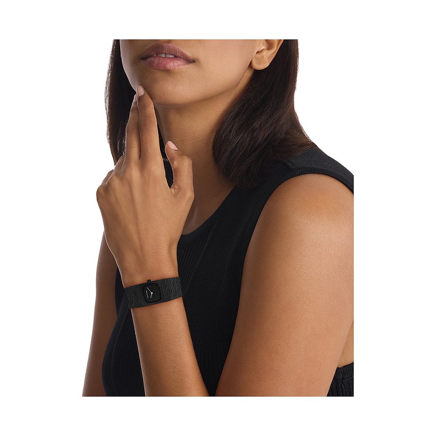 Eine Frau trägt eine Calvin Klein Damenuhr aus Edelstahl mit rechteckigem Zifferblatt und schwarzem Armband.